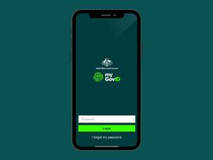 A smartphone screen displays the myGovID app login page by the Australian Government. The screen has fields for entering a password and buttons labeled "Login" and "I forgot my password." Ideal for a Tax Accountant or anyone seeking tax advice, the background is dark green.